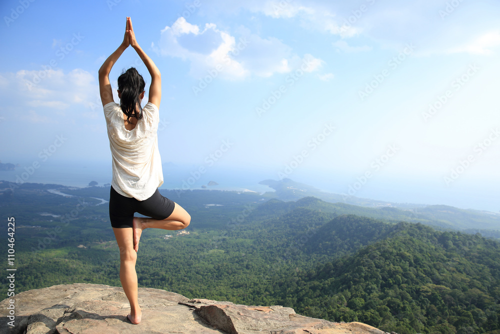 young fitness woman practice yoga at mountain peak cliff young fitness woman practice yoga at mountain peak cliff
