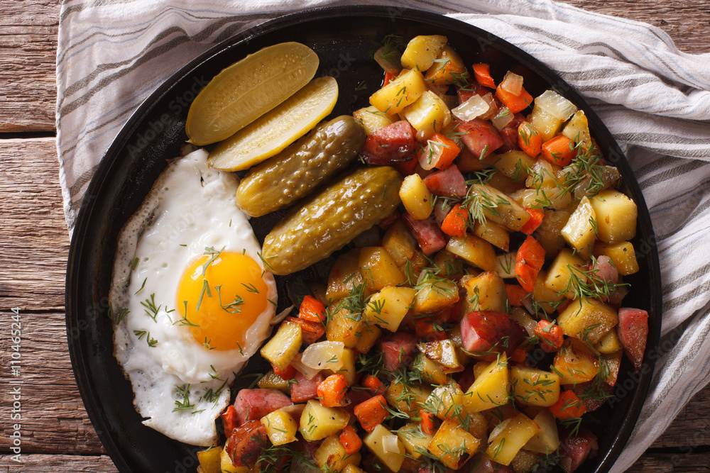 Norwegian food pyttipanne: fried potatoes with sausages, eggs close-up. horizontal top view
