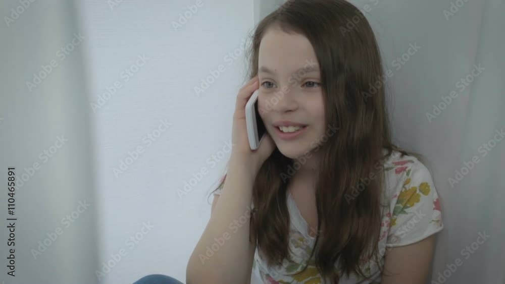 Beautiful happy little girl emotional talking on smartphone Beautiful happy little girl emotional talking on smartphone