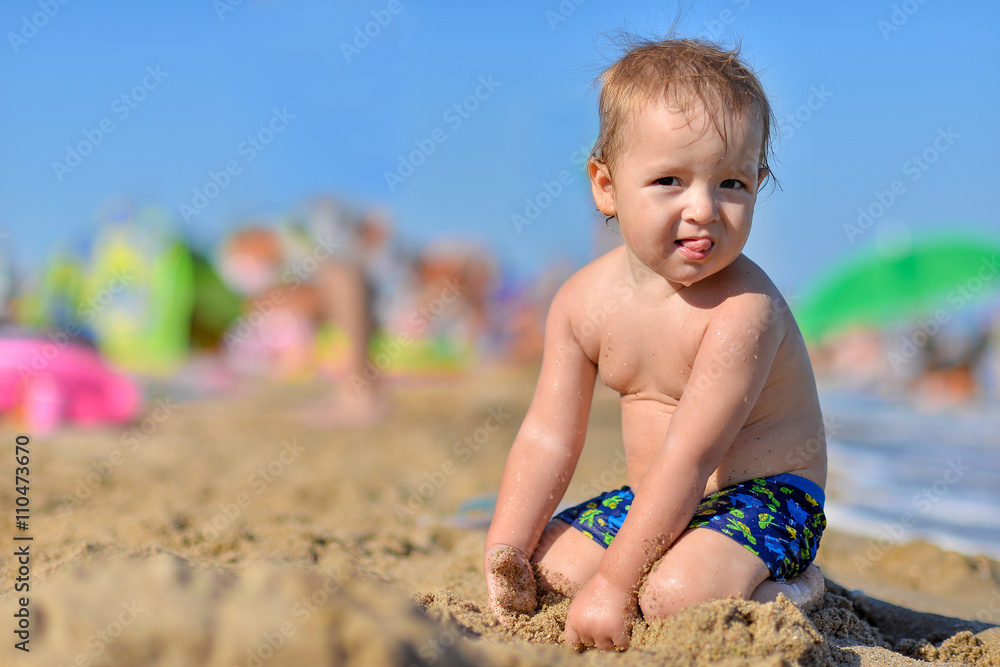 Baby playing with toys on the sandy beach near the sea. Baby playing with toys on the sandy beach near the sea.