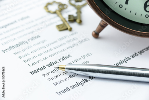 Canvas Print Blue ballpoint pen on a financial ratios analysis check lists with an antique clock and two vintage brass keys