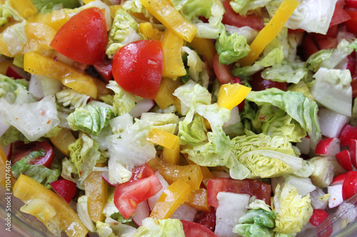 Mixed salad with various vegetables as background