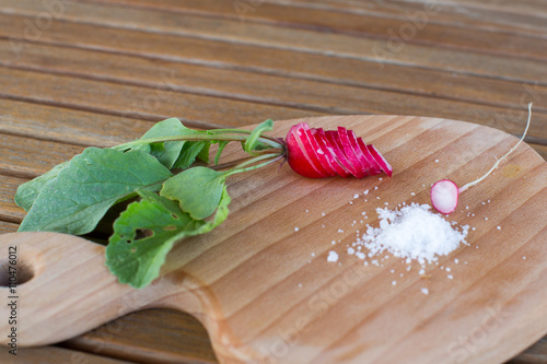 Fresh radishes and green onion on the white plate  summer photo.