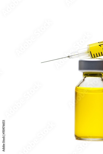 Syringe with yellow fluid on a white background