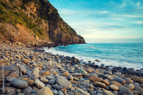 Fototapeta Naklejka Na Ścianę i Meble -  Deserted rocky pebble beach with clear blue water