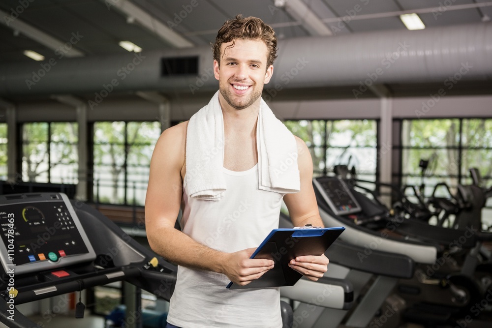 Gym instructor holding clipboard in gym Gym instructor holding clipboard in gym