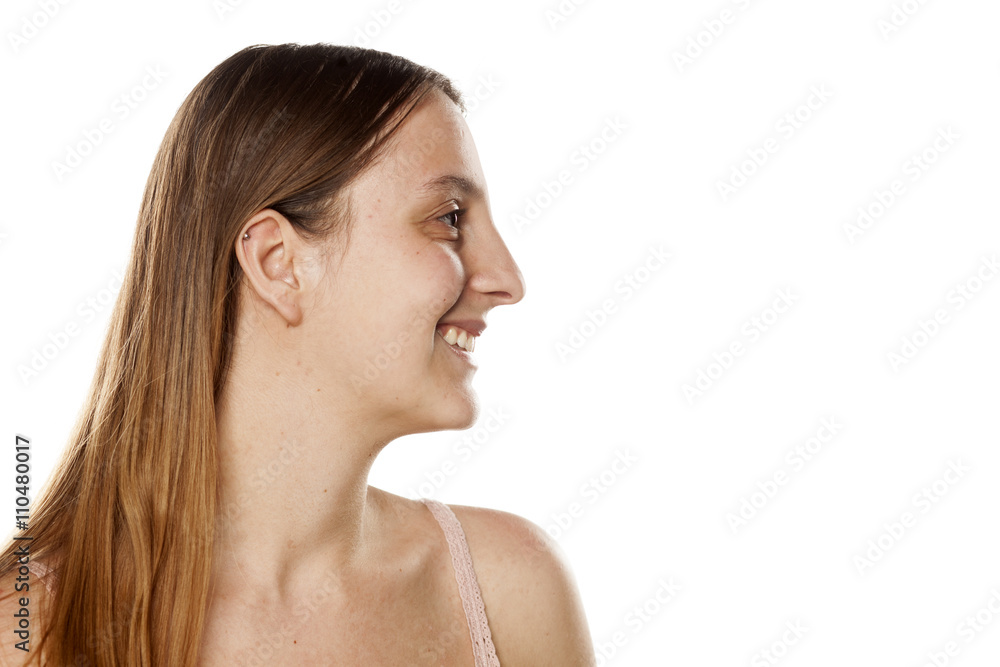 profile of a smiling young woman without makup on a white background profile of a smiling young woman without makup on a white background