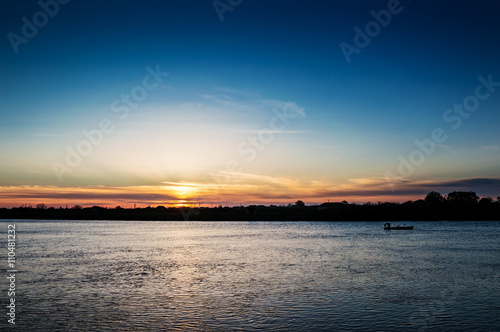 Fisherman's boat at beautiful sunset on the river