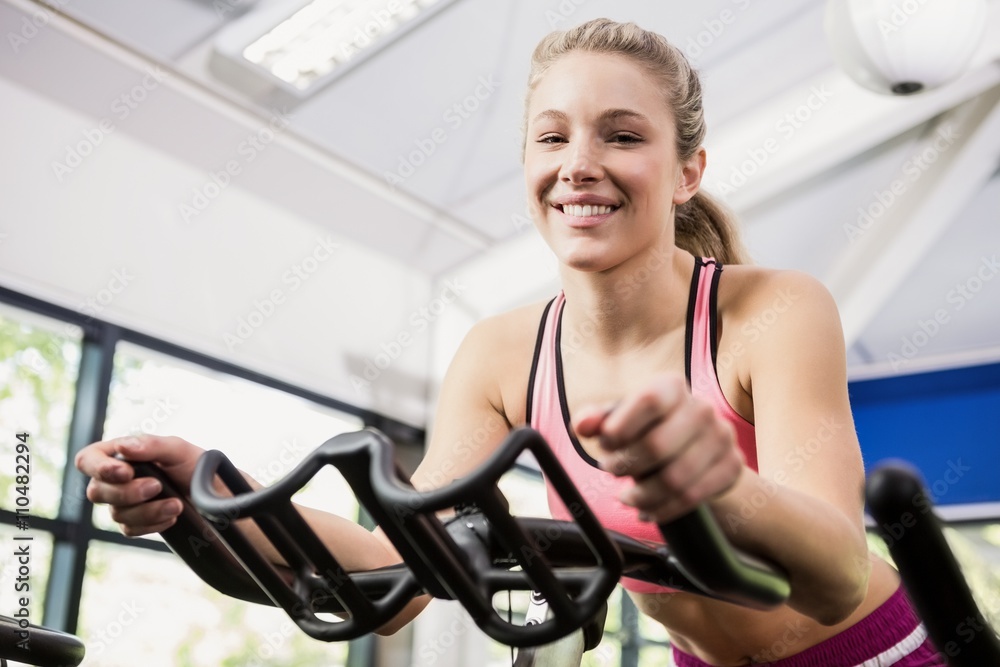 Obraz premium Woman working out on exercise bike at spinning class
