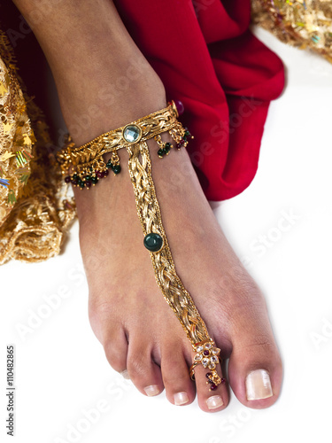 close-up shot of a woman wearing gold anklet.