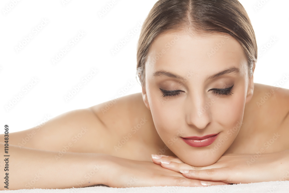 Portrait of beautiful young woman lying down on towel Portrait of beautiful young woman lying down on towel