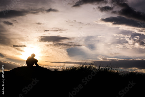 Sad boy silhouette worried on the meadow at sunset ,Silhouette c