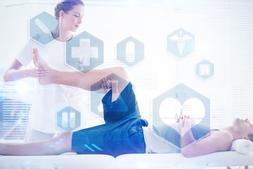 Composite image of physiotherapist massaging leg of man