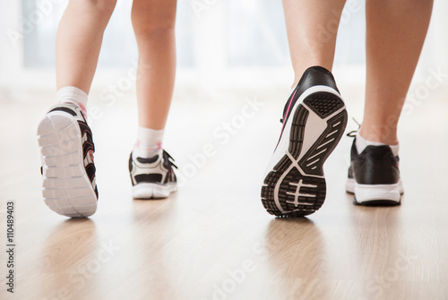 Child's and woman's legs in sports shoes