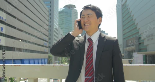 Japanese business man takes positive phone call gives ok sign