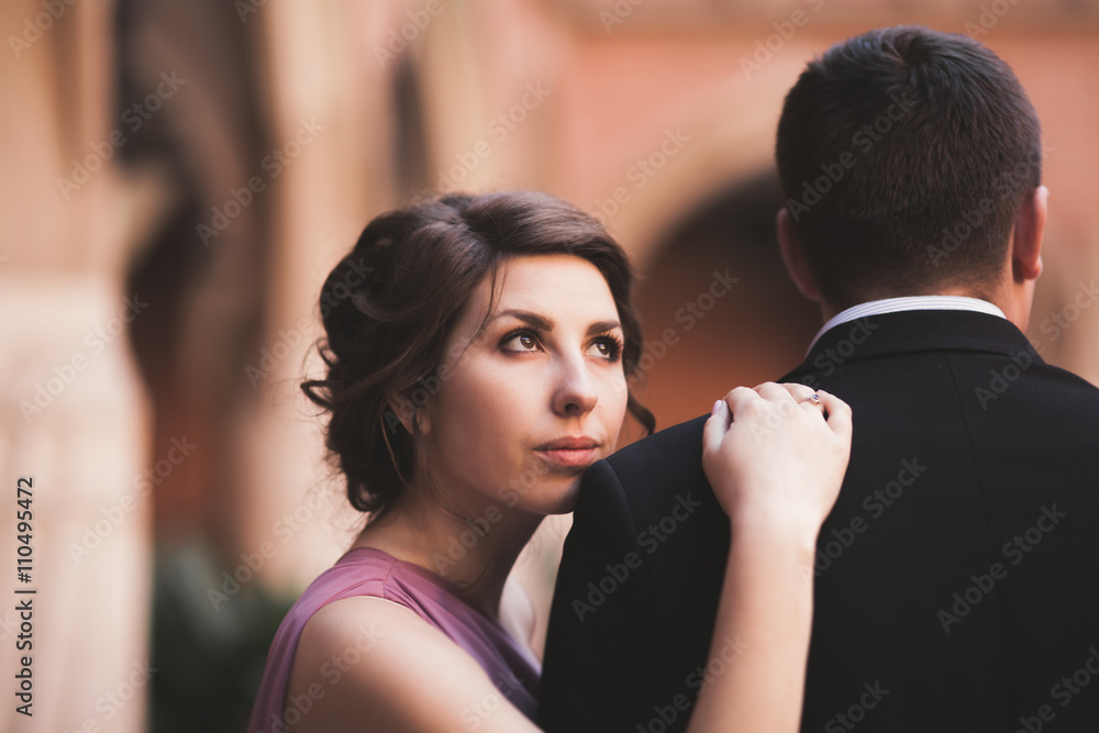 Young couple in love bride and groom posing near area with white columns on the background. Krakow Young couple in love bride and groom posing near area with white columns on the background. Krakow