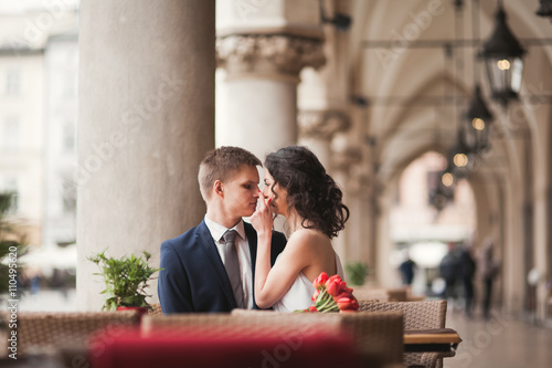 Wedding couple, man, girl sitting in cafe smiling and kissing