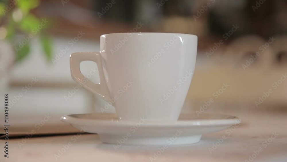 A man puts a cup of coffee on the table A man puts a cup of coffee on the table