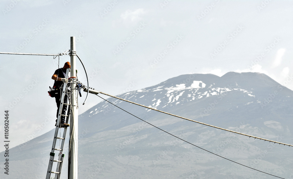 elettricista uomo al lavoro, su scala con palo e cavi