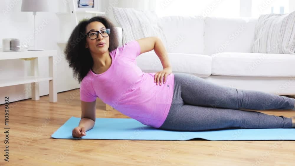 happy african woman exercising on mat at home happy african woman exercising on mat at home