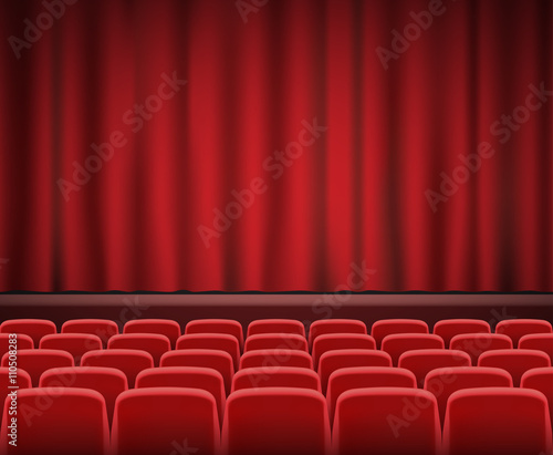 Rows of red cinema or theater seats in front of show stage