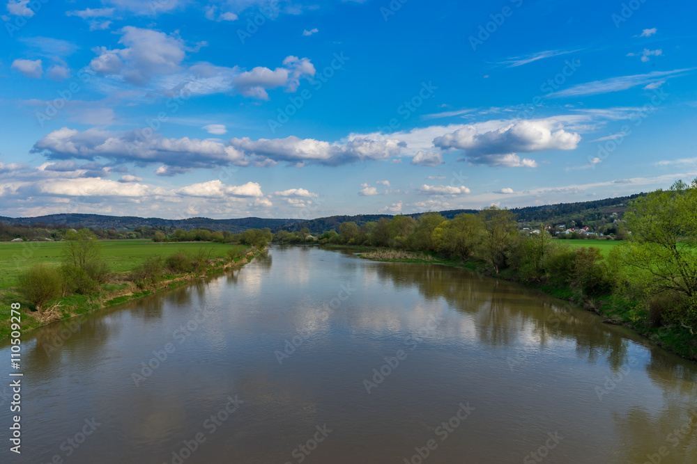 River floating through meadows on a sunny day, in springtime. In south-eastern Poland