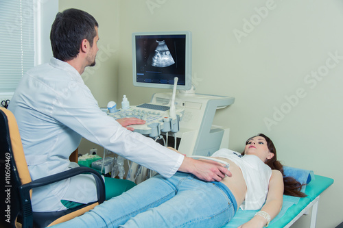  pregnant woman laying on the couch during the ultrasound checking 