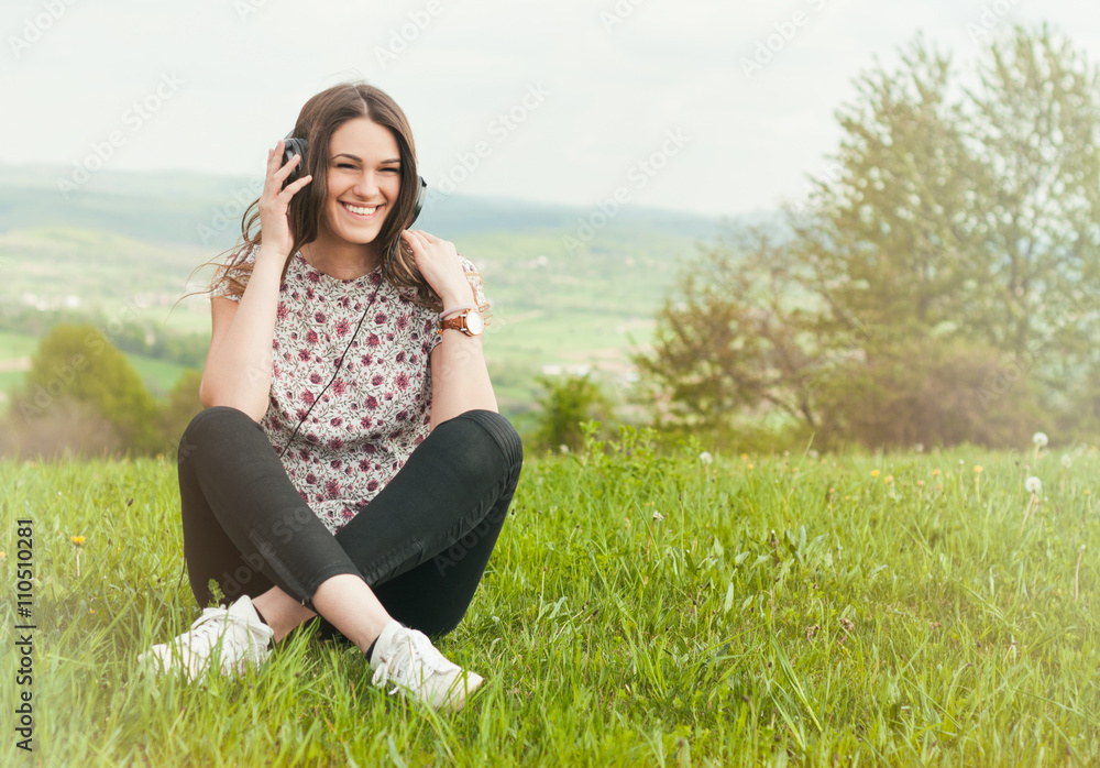 Beautiful young female with earphones outdoors enjoying music Beautiful young female with earphones outdoors enjoying music