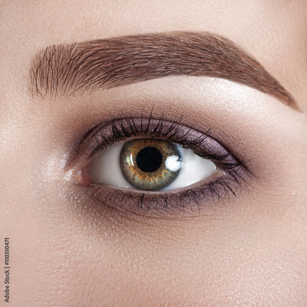 Obraz premium Female eye close-up. Macro. Perfect makeup and eyebrows. Beautiful green eyes