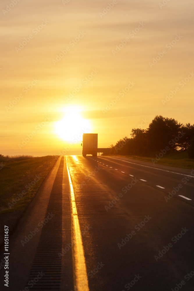 Trucking at sunrise on an empty road