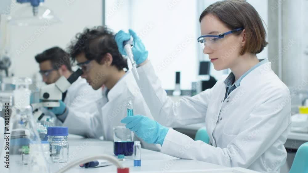 Group of Multiethnic Students in Coats Working in Laboratory of Chemistry Classroom. Shot on RED Cinema Camera. Group of Multiethnic Students in Coats Working in Laboratory of Chemistry Classroom. Shot on RED Cinema Camera.
