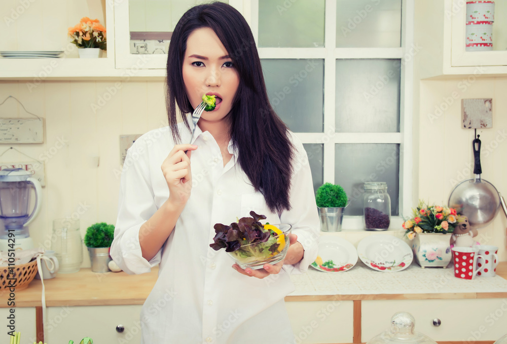 beautiful young woman eating a healthy salad in the kitchen beautiful young woman eating a healthy salad in the kitchen
