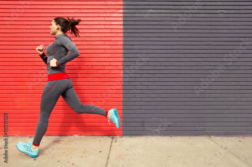 Healthy fit woman exercising with a run jog in the city sidewalk confident and powerful
