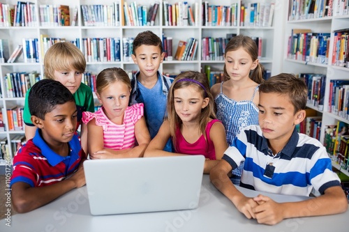 Cute pupils using laptop 