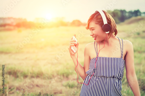 beautiful sexy woman with blue dress standing listening music in