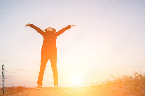 Young woman open arms under the sunrise at mountain