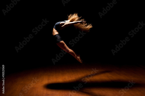 Beautiful dancer jumping in a stage