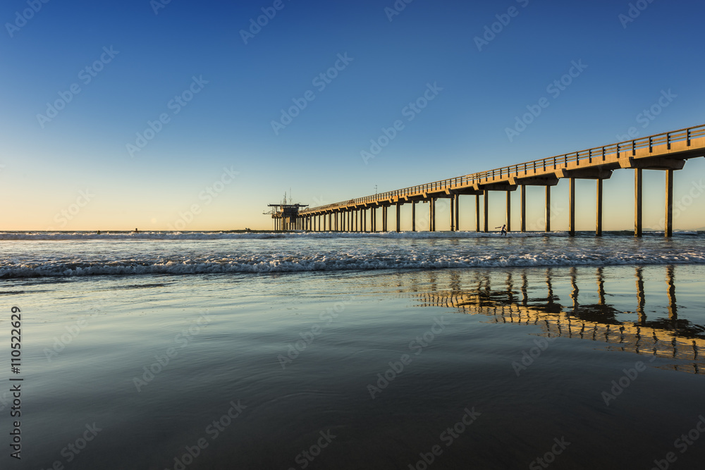 Wide angle shot of Scripps Pier with reflection during sunset in La Jolla, San Diego, California