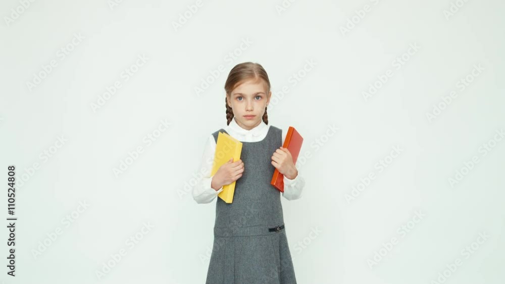 Schoolgirl 7-8 years holding books and looking at camera Schoolgirl 7-8 years holding books and looking at camera