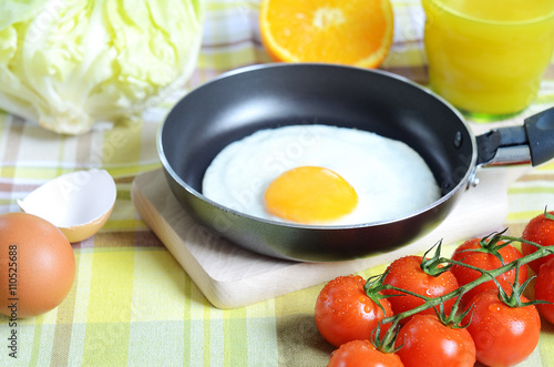 Fried egg, toast bread, fresh juice, tomatoes and oranges