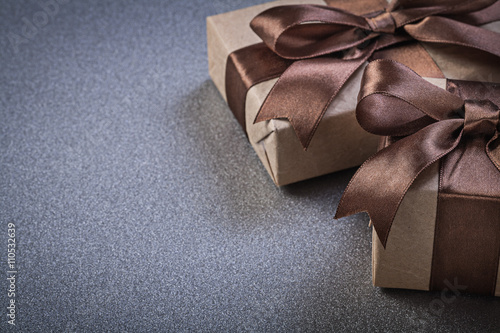 Boxed gifts in brown wrapping paper on grey background celebrati