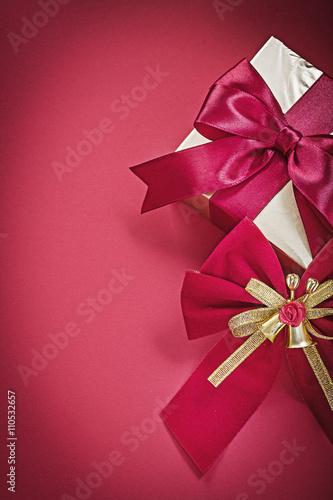 Christmas bow gift box on red surface holidays concept