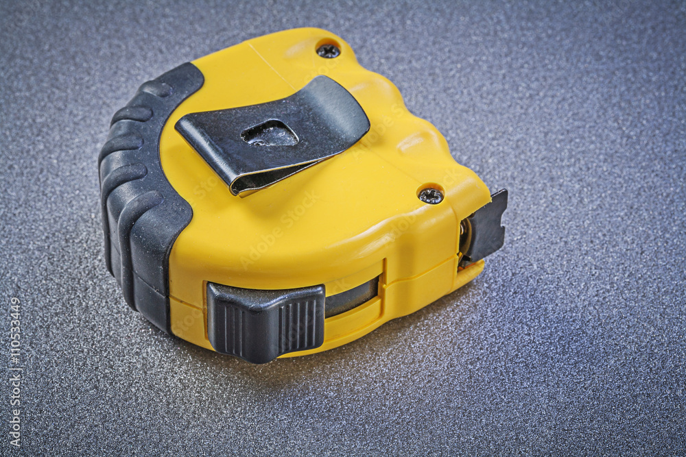 Tape-measure on grey background construction concept Tape-measure on grey background construction concept