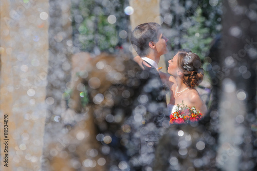 Wedding kiss in the park with a fountain