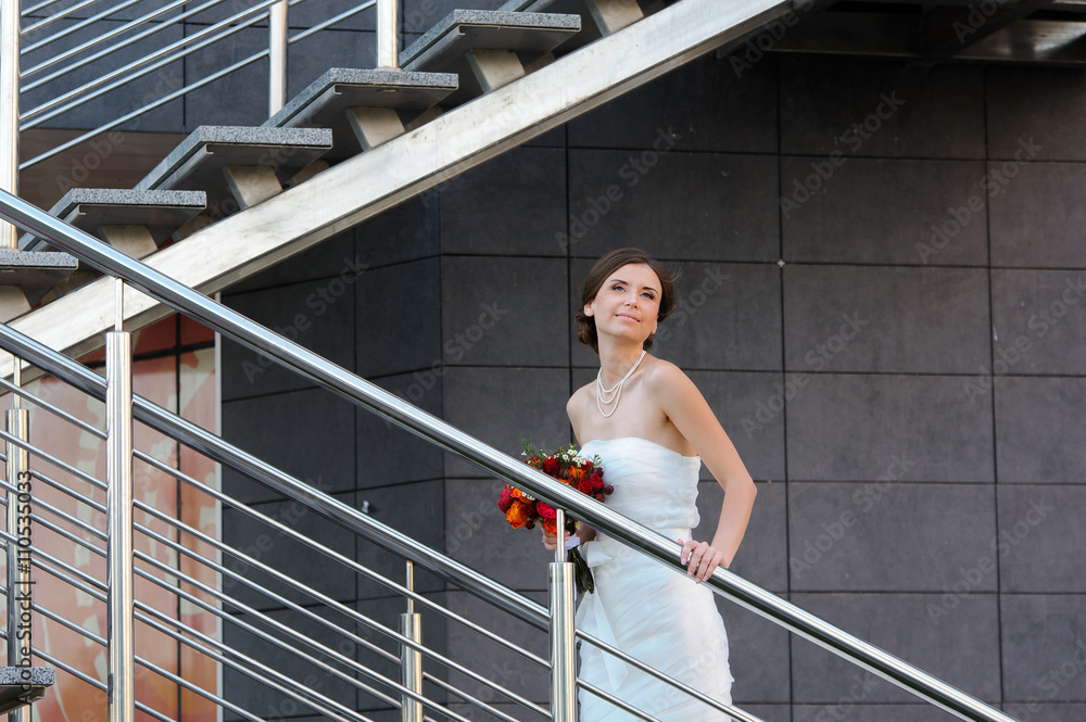 The bride in a beautiful modern metal staircase