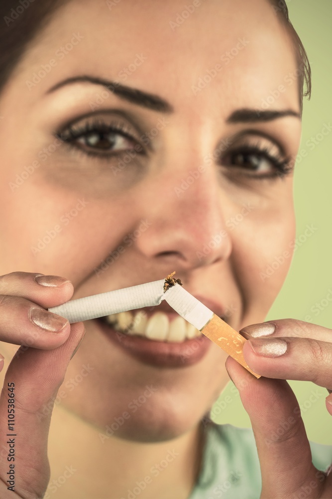 Composite image of close-up portrait of happy woman holding ciga Composite image of close-up portrait of happy woman holding ciga