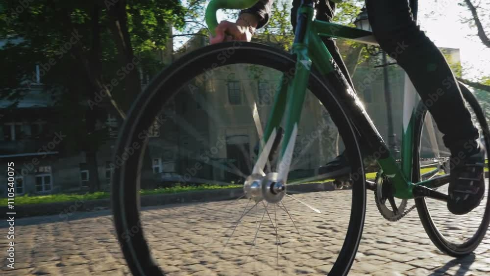 Young hipster man riding gixed gear bike in old city center, slow motion Young hipster man riding gixed gear bike in old city center, slow motion