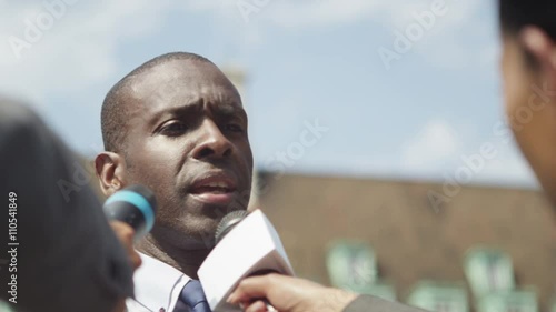  Businessman or politician giving live interview to news reporters
