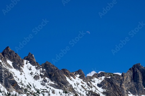 Snow Capped Mountains Peaks, Sky and Moon. North Cascades National Park, Washington Pass, Washington State, USA. 