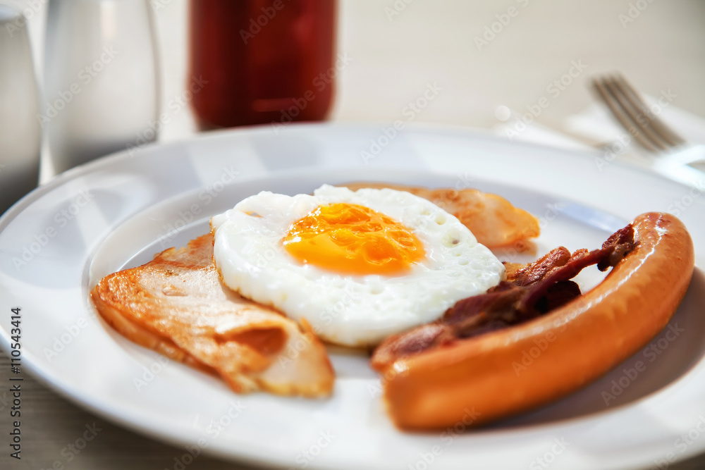 Breakfast set eggs, ham, sausage and bacon under morning light (selective focus) Breakfast set eggs, ham, sausage and bacon under morning light (selective focus)